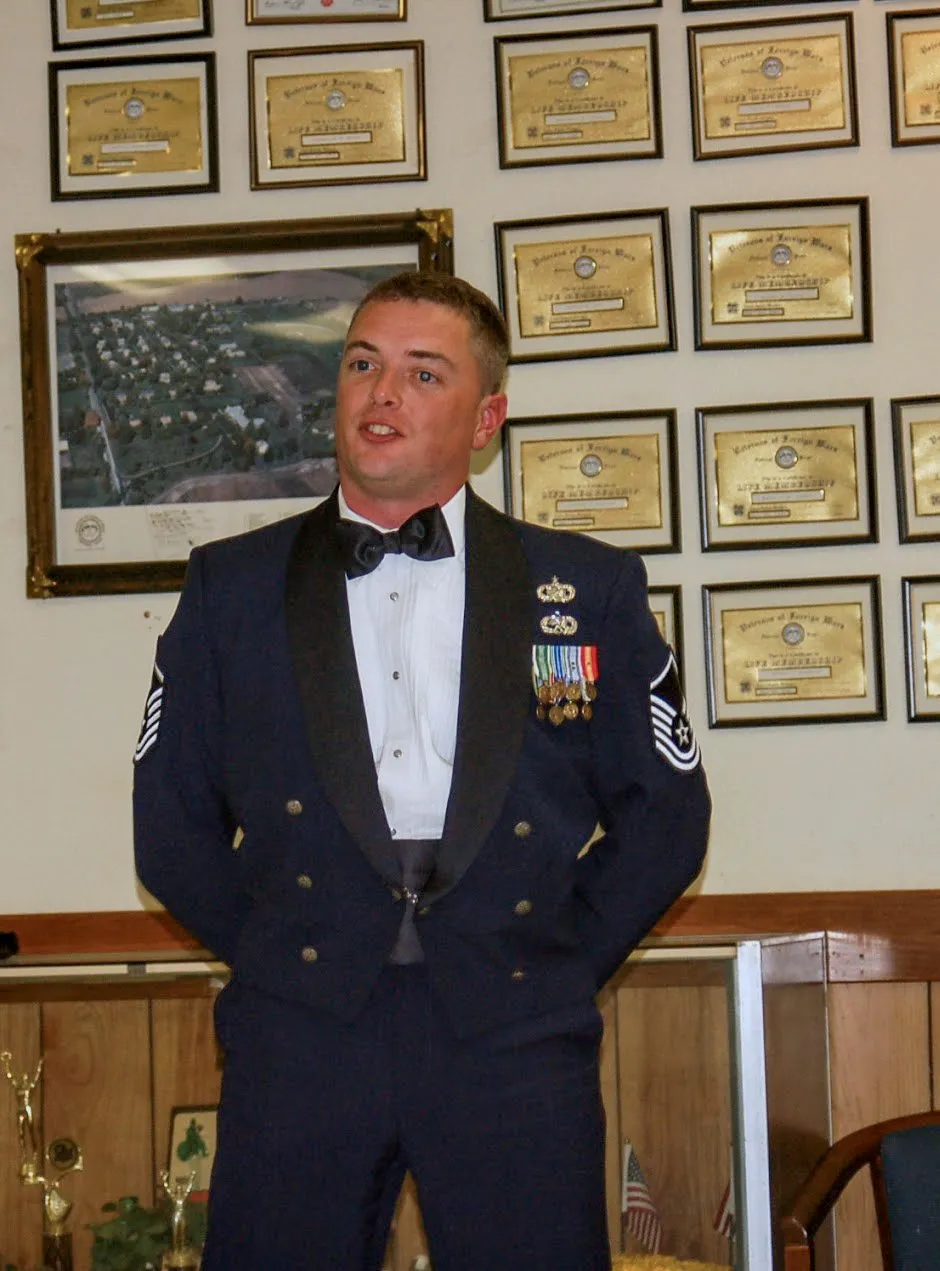 Corey Frasure in Air Force mess dress, speaking to a room