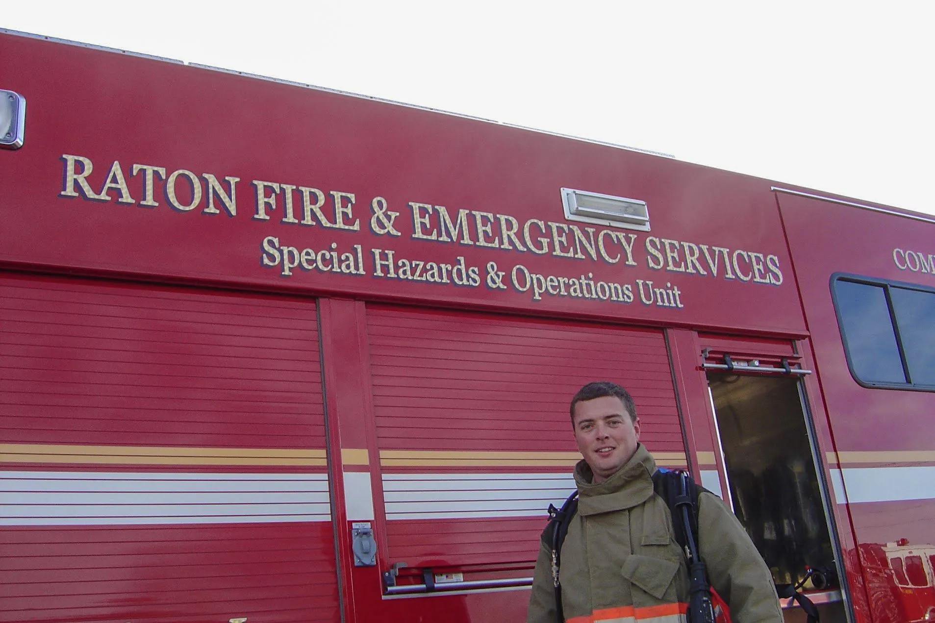 Corey Frasure in turnout gear in front of a fire department special hazards truck